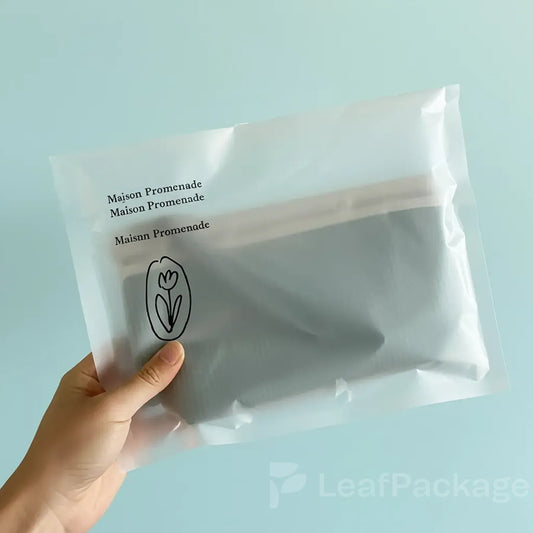Eco-friendly glassine paper bags for clothing packaging, fully recyclable and customizable with logo.