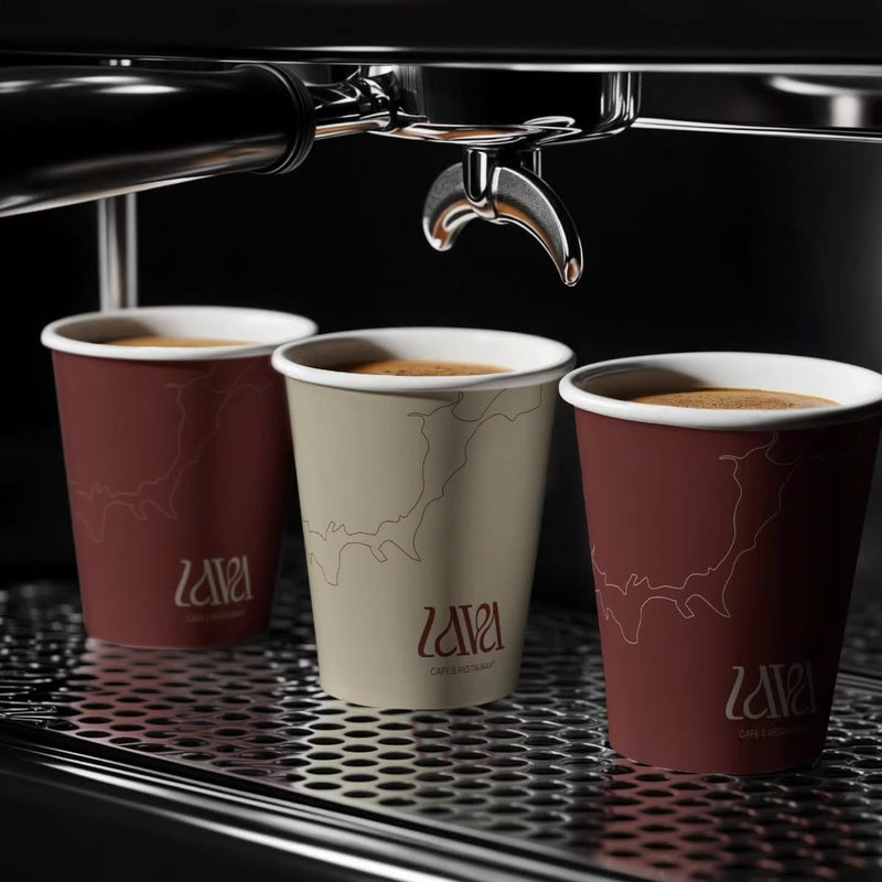 Custom soft touch matte paper coffee cups under an espresso machine